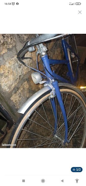 Vélo de ville vintage à l'ancienne bleu avec garde boue et porte bagage arrière en métal. image