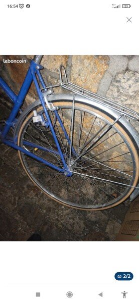 Vélo de ville vintage à l'ancienne bleu avec garde boue et porte bagage arrière en métal. image